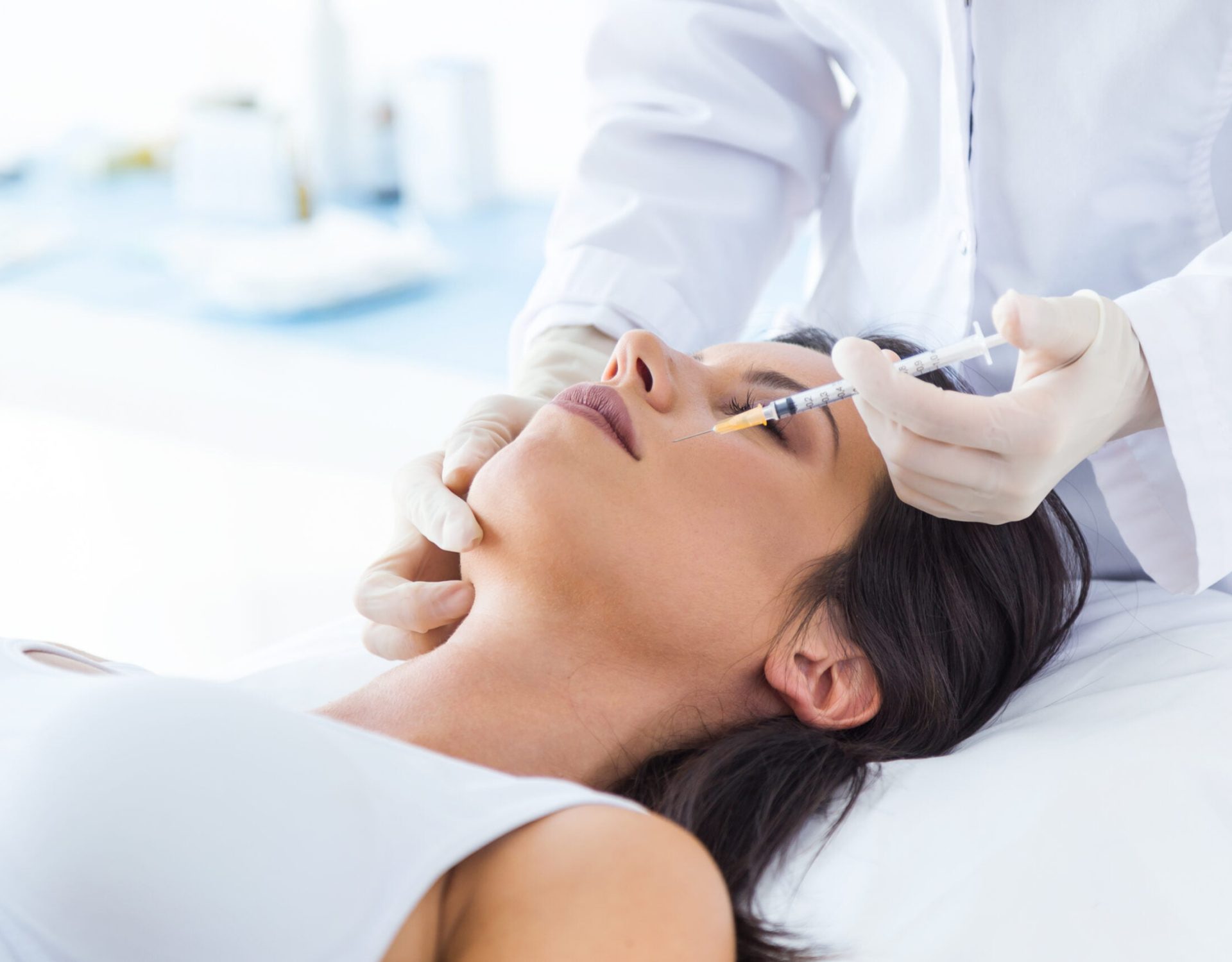 Portrait of beautiful young woman getting botox cosmetic injection in her face.